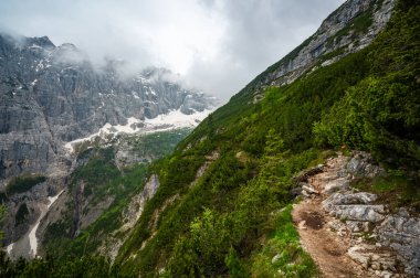 Dolomitler 'deki dağ patikaları (Dolomiti, Dolomiten), İtalya, Lago Sorapis' e çıkar. Yol kayalık yamaçlar boyunca esiyor, vadilerin, ormanların ve tepelerin çarpıcı manzarasıyla.