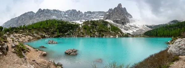 Dolomiti (Dolomiti, Dolomiten), İtalya 'daki Lago Sorapis' in panoramik görüntüsü. Turkuaz göl, doğa severler ve yürüyüşçüler için popüler bir yer olan yüksek uçurumlar ve dağlarla çevrilidir.
