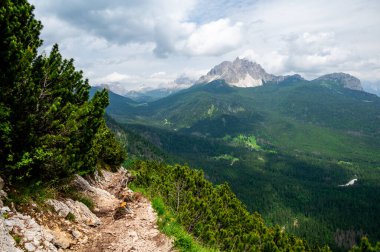 İtalyan Dolomitleri 'ndeki (Dolomiti, Dolomiten) ormanların, dağların ve vadilerin nefes kesici manzarası. Kayalık bir çıkıntı boyunca manzaralı bir patikadan yakalanmış. Büyüleyici alp doğası.