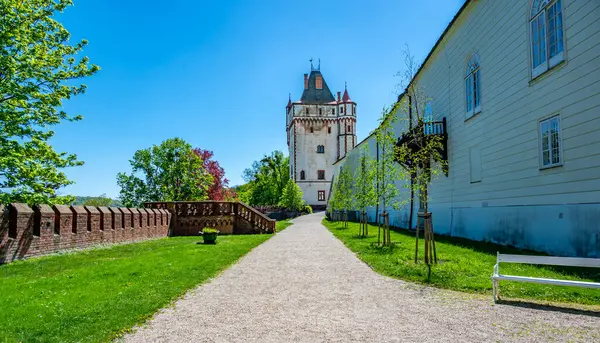 Çek Cumhuriyeti 'nde Hradec nad Moravici Şatosu yakınlarında, gökyüzüne karşı dik duran beyaz kule. Çarpıcı beyaz rengi çevresindeki yeşillik ve tarihi yapılarla çelişiyor..
