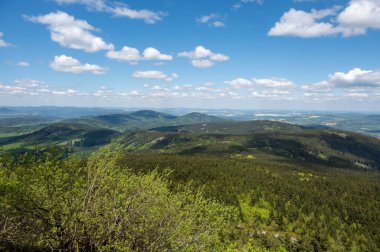 Ön planda Virive kameny taş oluşumuyla Jested dağından ve açık mavi gökyüzünün altında uzanan Liberec şehrinden görüntü.