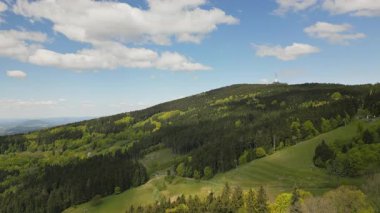 Yamaç paraşütçüleri ve planörlerin havada süzüldüğü ikonik kulesiyle Jested Dağı 'nın etrafındaki orman ve çayır görüntüleri..