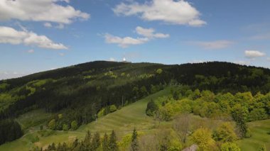 Yamaç paraşütçüleri ve planörlerin havada süzüldüğü ikonik kulesiyle Jested Dağı 'nın etrafındaki orman ve çayır görüntüleri..