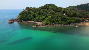 Tayland 'daki Ko Lanta adasının beyaz kumsal, turkuaz deniz, kayalık kayalıklar, küçük tekneler ve bereketli tropikal yamaç ve egzotik ve popüler tatil beldeleri ile hava manzarası..