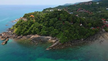 Tayland 'daki Ko Lanta adasının beyaz kumsal, turkuaz deniz, kayalık kayalıklar, küçük tekneler ve bereketli tropikal yamaç ve egzotik ve popüler tatil beldeleri ile hava manzarası..
