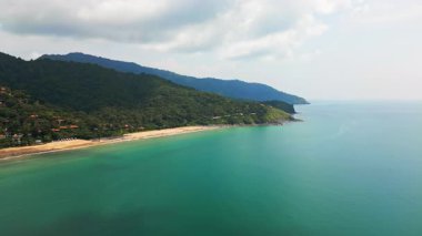 Tayland 'daki Ko Lanta adasının beyaz kumsal, turkuaz deniz, kayalık kayalıklar, küçük tekneler ve bereketli tropikal yamaç ve egzotik ve popüler tatil beldeleri ile hava manzarası..