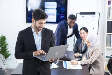 Genç yönetici şirketin online iş toplantıları için bir not defterine bakıyor.