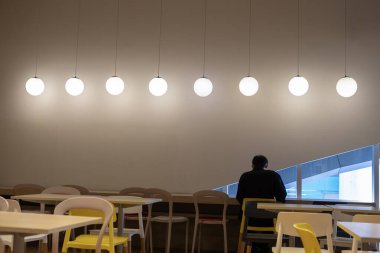 Fast food restoranının içinde oturuyor.