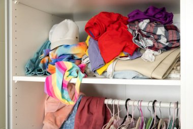 Dağınık renkli şeylerin yakın çekimi. Ahşap çekmeceler ağzına kadar dağınık şeylerle doludur. Mekan, çamaşır, ev temizliği kavramı.