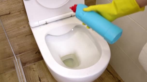 青いボトルの液体洗浄ソリューションを使用して黄色の保護手袋の女性の手のクローズアップは トイレのフラッシュ 消毒や衛生コンセプトをきれいにします 掃除や部屋の衛生 — ストック動画