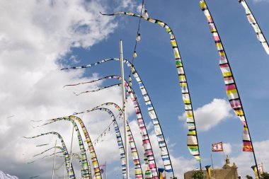 Rüzgarda dalgalanan renkli bayraklar canlı ve dinamik bir sahne yaratıyor..