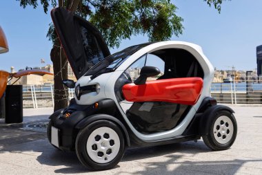 Rıhtım kenarında açık kapıları olan kompakt elektrikli araba, turizm için çevre dostu şehir ulaşımı