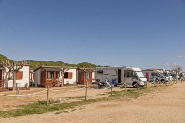 İspanya 'da tahta kulübeler, karavanlar ve kamyonlarla deniz kenarında kamp yapmak. Özgürlük, seyahat ve aile macerası