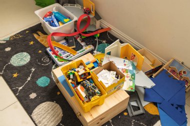 Yere saçılmış oyuncaklar, bloklar ve inşaat malzemeleri. Çocukluk karmaşası, yaratıcılık ve iş başında öğrenme.