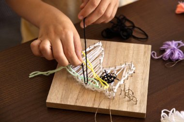 Çocuk ipliği ince tırnaklara sarar, sabır, odaklanma ve sanatsal beceriler geliştirir..