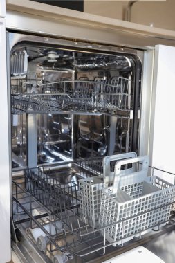 Boş rafları ve sepeti olan açık ve temiz bulaşık makinesi, metal ve plastik parçalarla iç görünümü.
