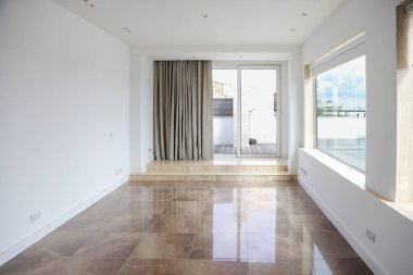 Geniş, içi boş bir pencere, mermer zemin, perde, kapı ve doğal gün ışığı..