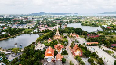 Hava aracı görüntüsü, sırt çantalı gezgin Wat Chalong 'da ya da Tayland' ın Phuket kasabasındaki Chalong tapınağında güzel bir pagoda 'ya seyahat ediyor. Phuket Tayland 'daki en popüler Tayland tapınağı..