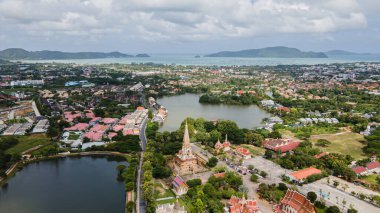 Hava aracı görüntüsü, sırt çantalı gezgin Wat Chalong 'da ya da Tayland' ın Phuket kasabasındaki Chalong tapınağında güzel bir pagoda 'ya seyahat ediyor. Phuket Tayland 'daki en popüler Tayland tapınağı..