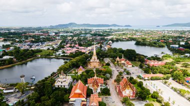 Hava aracı görüntüsü, sırt çantalı gezgin Wat Chalong 'da ya da Tayland' ın Phuket kasabasındaki Chalong tapınağında güzel bir pagoda 'ya seyahat ediyor. Phuket Tayland 'daki en popüler Tayland tapınağı..