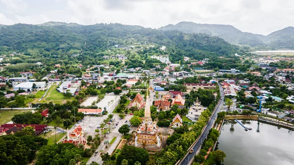 stock image Drone aerial view , traveler with backpack traveling into beautiful pagoda in Wat Chalong or Chalong temple at Phuket town, Thailand. It's most popular thai temple in Phuket Thailand.