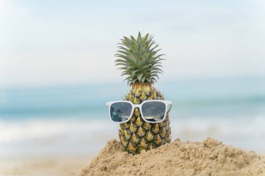 Plaj meyvesi turizminde ananaslardan yapılmış meyveli adam sağlık için komik ve tatlı güneş banyosu meyveleri. Kutlama yemeği. Yaz yolculuğu konsepti. Kopyalama alanını ziyaret etmek için beyaz arkaplan tasarımı daveti