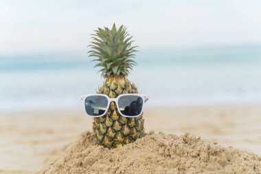 Plaj meyvesi turizminde ananaslardan yapılmış meyveli adam sağlık için komik ve tatlı güneş banyosu meyveleri. Kutlama yemeği. Yaz yolculuğu konsepti. Kopyalama alanını ziyaret etmek için beyaz arkaplan tasarımı daveti