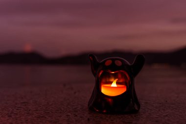 Cadılar Bayramı kumsalı ve okyanus arka planında cadı hayaleti ateşi, karanlık ve korkutucu bir ses tonu var..