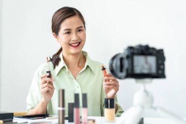 Kadın blogcu, makyaj malzemesi kozmetik inceleme ürünü ve canlı yayın videosunu kamera ekranında sosyal ağ öğretimine gösteriyor..