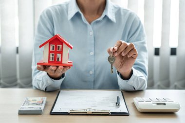 Emlak komisyoncusu, satış sözleşmesinin kira kontratını imzaladıktan sonra müşterinin anahtarlarını tutuyor..