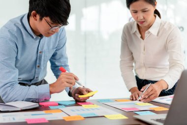 İşletme yürütme ekibi beyin fırtınası yapıyor ve ofiste birlikte pazarlama planlaması için yeni bir iş projesiyle ilgili notlar alıyor..