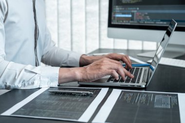 Masaüstü bilgisayarında yazılım geliştirme projesinde çalışan ve kodlama ve veri kodu parola güvenliği yazan erkek programcı.