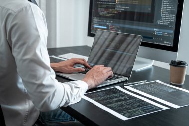 Masaüstü bilgisayarında yazılım geliştirme projesinde çalışan ve kodlama ve veri kodu parola güvenliği yazan erkek programcı.