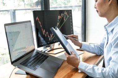 İş kadını yatırımcı, bir borsada sunulan verileri ekranda göstererek grafik verilerini planlayıp analiz ediyor..