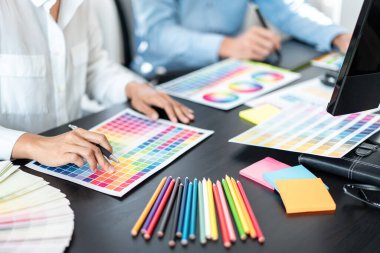 Renk seçimi ve grafik tablet üzerinde çalışan iki yaratıcı grafik tasarımcı ekibi, iş yerindeki yaratıcılığa ilham vermek için renk örneklerinin şeması.