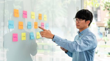 İş adamı yöneticisi düşünme ve yeni bir pazarlama projesinin planlanmasında kullanılacak anahtar kelimeyi not alıyor..