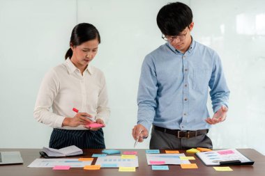 İşletme yürütme ekibi beyin fırtınası yapıyor ve ofiste birlikte pazarlama planlaması için yeni bir iş projesiyle ilgili notlar alıyor..