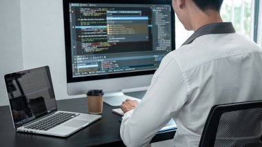 Masaüstü bilgisayarında yazılım geliştirme projesinde çalışan ve kodlama ve veri kodu parola güvenliği yazan erkek programcı.