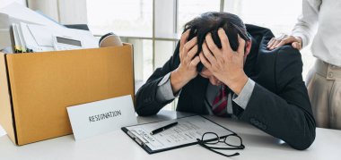 Tüm kişisel eşyalarını ve dosyalarını kahverengi bir karton kutuya koyan İşadamı, istifa etmek ve ofiste iptal sözleşmesi imzalamak için sinirlendi ve vurguladı..