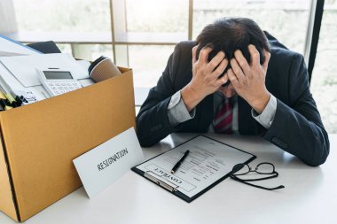 Tüm kişisel eşyalarını ve dosyalarını kahverengi bir karton kutuya koyan İşadamı, istifa etmek ve ofiste iptal sözleşmesi imzalamak için sinirlendi ve vurguladı..