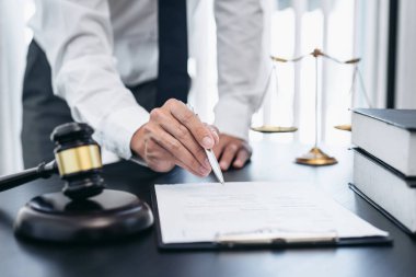 Sözleşme kağıtları, hukuk kitapları ve ahşap tokmakla çalışan erkek avukat mahkeme salonunda, hukuk ve hukuk hizmetleri kavramında..