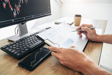 Bilgisayarla çalışan, düşünen ve analiz eden bir işadamı, hisse senedi grafiği veri planlama, finans ve yatırım konseptiyle borsa ticareti yapıyor..