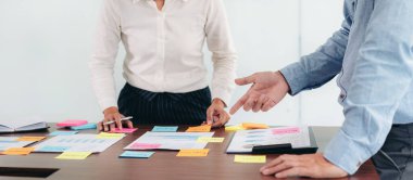 İşletme yürütme ekibi beyin fırtınası yapıyor ve ofiste birlikte pazarlama planlaması için yeni bir iş projesiyle ilgili notlar alıyor..