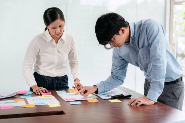 İşletme yürütme ekibi beyin fırtınası yapıyor ve ofiste birlikte pazarlama planlaması için yeni bir iş projesiyle ilgili notlar alıyor..