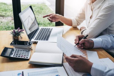 İki işletme yöneticisi yeni proje başarı istatistikleri ile tartışıyorlar, Ortaklar her iki şirket için profesyonel yatırımcılarla görüşüyor belge ile birlikte proje başlatıyorlar.