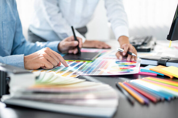 Team of creative graphic designer working on color swatch samples chart for selection coloring in inspiration to create new collection at workplace