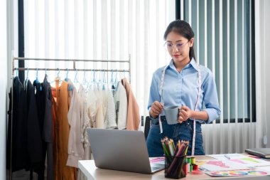 Profesyonel kadın moda tasarımcısı çalışıyor ve düşünüyor. Yeni kıyafet koleksiyonu malzemesi ve renk örneği seçmeye karar veriyor..
