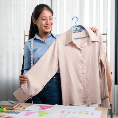 Profesyonel kadın moda tasarımcısı çalışıyor ve düşünüyor. Yeni kıyafet koleksiyonu malzemesi ve renk örneği seçmeye karar veriyor..