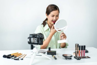 Kadın blogcu, makyaj malzemesi kozmetik inceleme ürünü ve canlı yayın videosunu kamera ekranında sosyal ağ öğretimine gösteriyor..