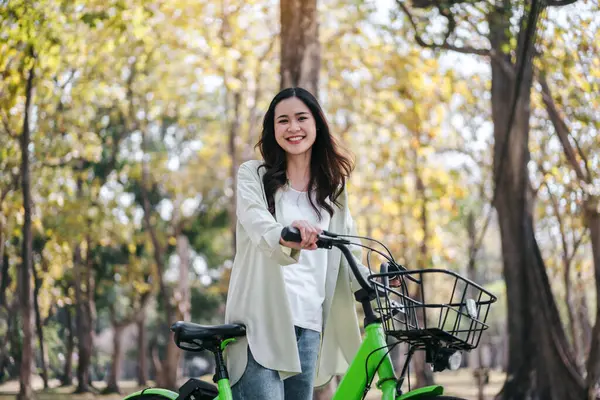 Seorang Wanita Tersenyum Dan Mengendarai Sepeda Hijau Konsep Kebahagiaan Dan Stok Foto Bebas Royalti